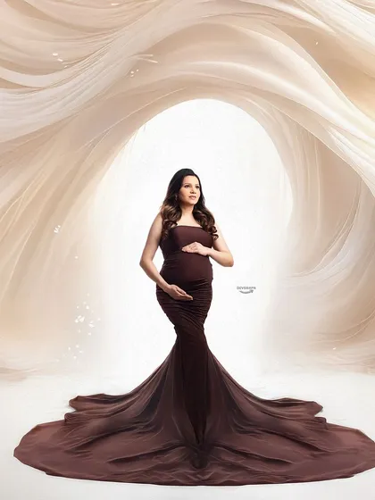 A dramatic and powerful portrait featuring a fitted brown gown. The swirling fabric effect in the background creates a sense of movement and artistry, framing the client beautifully.