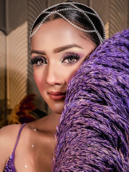 This shot highlights the sparkling headpiece and the beautiful, iridescent quality of the eye makeup.