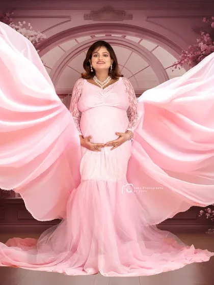 A dramatic and glamorous studio shot using flowing fabric to create angel-like wings. This style adds a touch of high fashion to your maternity session, making you feel like a star.