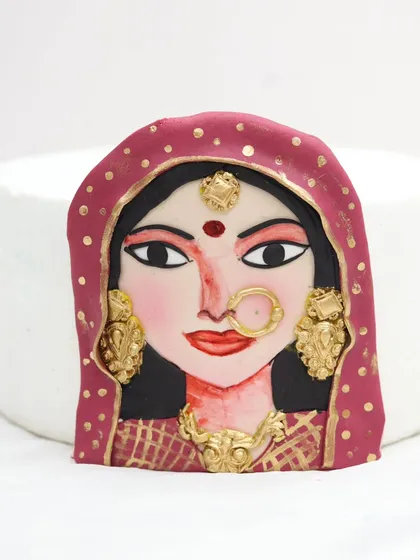 A hand-painted Indian bride portrait on a fondant plaque. This level of detail is perfect for adding a personal and artistic touch to wedding or bridal shower cakes.