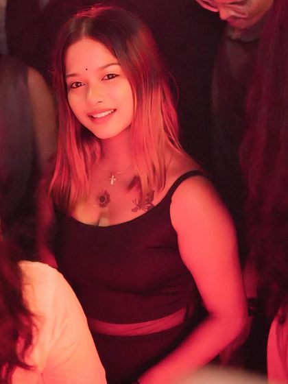 A close-up of a guest in the crowd, lit by the warm red lights of the club.