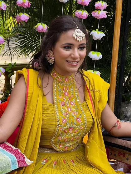 A happy mehendi bride, her smile as bright as her yellow outfit.