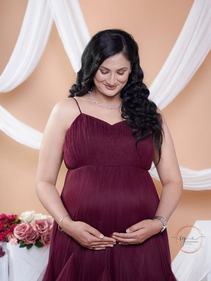 A quiet moment of connection. The mom-to-be looks down at her bump, her expression full of love and anticipation.