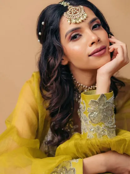 A close-up portrait that captures the essence of this Mehendi look. The eyes are the focus, with soft shimmer and definition, paired with a natural lip.