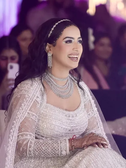 A candid moment of pure joy. This photo captures how the glittery, grand cocktail makeup comes alive when she smiles. The look was designed to be a showstopper, and her happiness makes it shine even brighter.