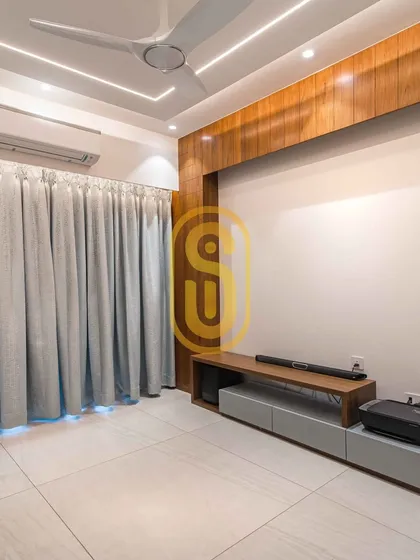 A minimalist TV unit designed for a clean and uncluttered look. The wooden paneling on the wall adds warmth, while the low-profile console provides essential storage without overwhelming the space.