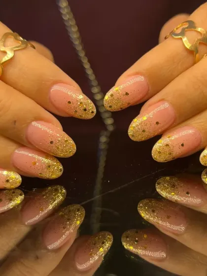 A gorgeous glitter fade manicure, with gold glitter cascading down from the tips on a sheer pink base.