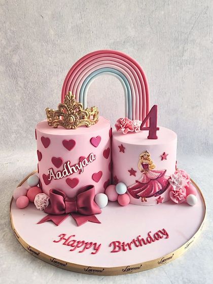 A Barbie-themed cake for Aadhyaa's 4th birthday. This double-cake design features a crown, hearts, and a Barbie silhouette.