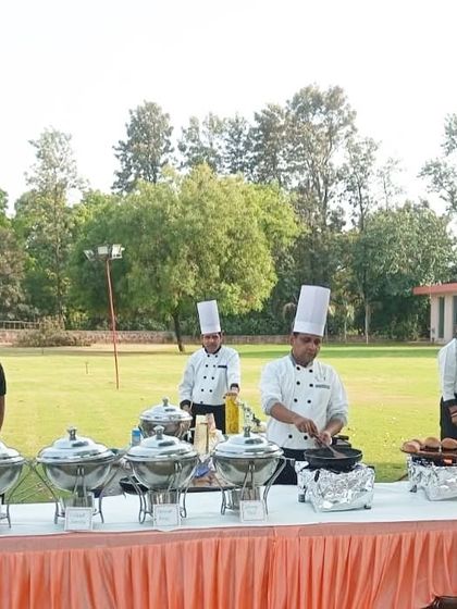 Our team of chefs at an outdoor live station, preparing burgers and other grilled items. We can set up a complete live kitchen in any outdoor venue to serve fresh and hot food.