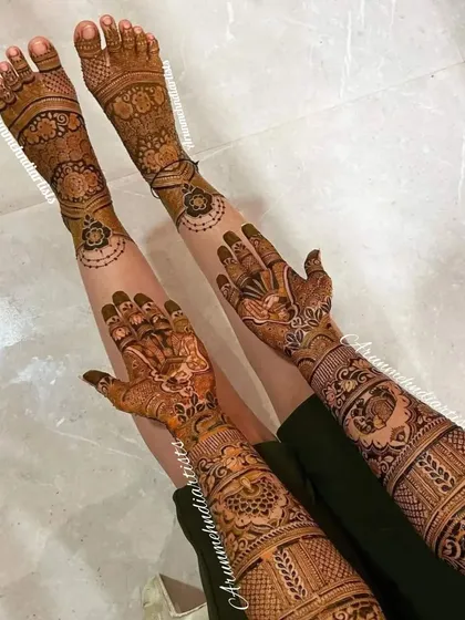 This image shows a full bridal mehndi application, with intricate designs covering the arms and legs, creating a stunning and complete look for the bride.