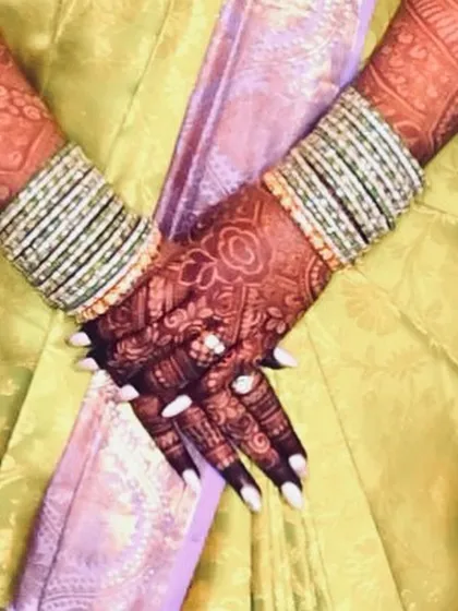 A beautiful candid shot showing the rich henna stain. It looks so elegant paired with the bride's bangles and outfit.