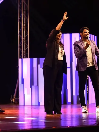 Geeta Kapur waving to the cheering crowd while I host the segment. My job is to facilitate these moments, connecting the stars with their fans in the audience.
