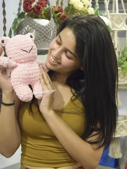 Holding our pink frog plushie. We can customize our toys in a variety of colors to create the perfect gift.