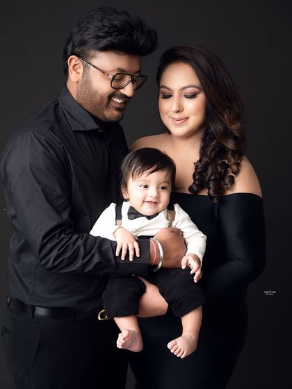 A classic family portrait against a dark grey background, making their expressions pop.