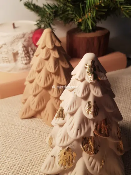 A close-up of our two Jesmonite Christmas tree designs. The contrast between the natural finish and the gold-leaf accented tree shows the different ways we love to style our pieces.