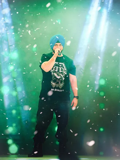 A close-up of singer Manmeet Singh during his performance, with confetti falling around him. This shot captures the intimate, high-energy moment of a live concert.