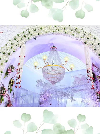 A peek through a floral arch reveals the magic within. A delicate chandelier hangs in the center, framed by white flowers, hinting at the elegance of the event.