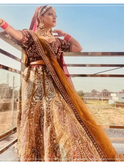 A bride posing in a traditional lehenga, looking absolutely beautiful against the sky.