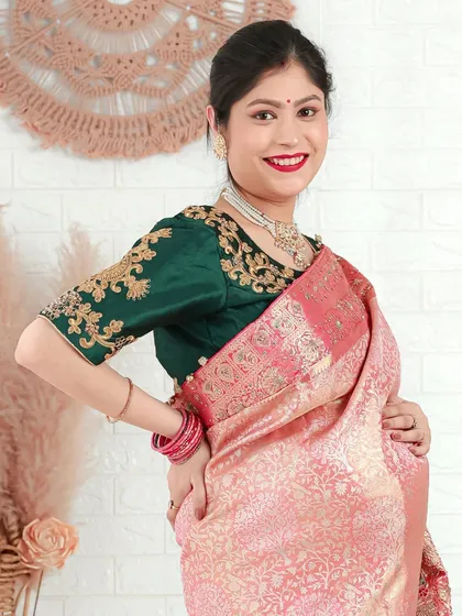 A vibrant and joyful portrait. The combination of a pink saree and an embroidered green blouse makes for a stunning and colorful celebration of motherhood.