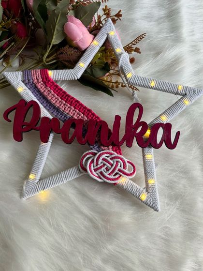 A top-down view of the "Pranika" star hanging with its lights on. It’s a wonderful gift for birthdays or baby showers.
