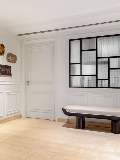 A minimalist bench from our Koko collection provides a serene seating nook in the passage of the Magnolia project. Its simple, sculptural form is a quiet counterpoint to the bold textural artworks on the wall, creating a harmonious balance.