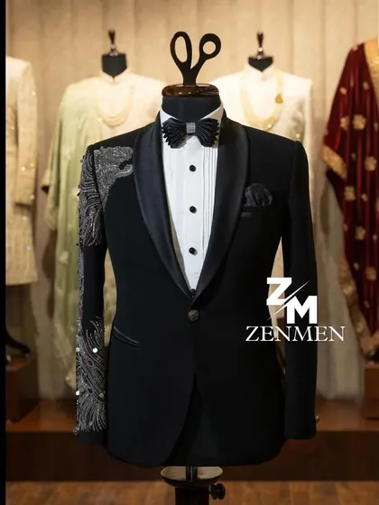 For the man who commands attention, this classic black tuxedo is elevated with striking silver hand embellishments on the sleeve and shoulder. It's a perfect example of modern luxury for a reception or black-tie event.