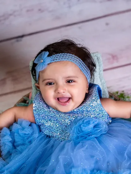 That happy grin says it all. Sitter sessions are perfect for capturing the adorable milestone when your baby can sit up on their own, showing off their chubby cheeks and budding personality.