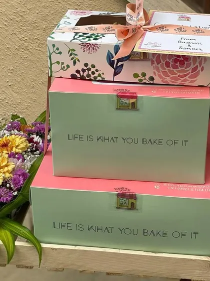 An example of stacked gifting for a big celebration. This features multiple boxes of my treats, elegantly stacked and tied with a ribbon, accompanied by a small bouquet.