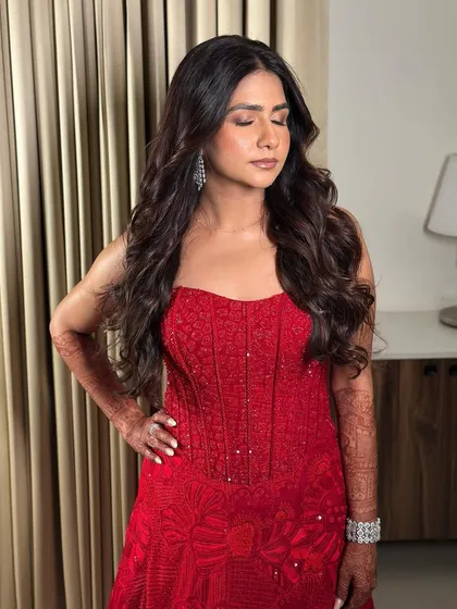 Eyes closed, showing the soft, neutral eyeshadow. This allows the bold red dress and the bride's natural beauty to be the main focus.