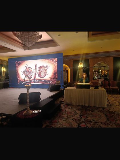 A wide shot of the stage setup for the Max Healthcare event, showing how the live art is projected for the entire audience to see.