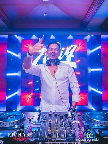 A confident pose in front of the vibrant red and blue LED wall at the NYE 2025 party.