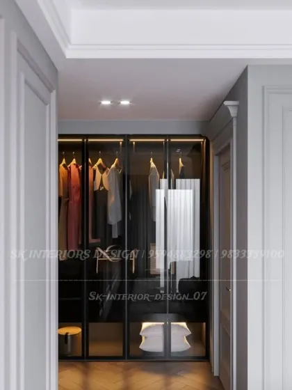 A glimpse into a walk-in closet with glass-fronted doors and internal lighting. This design allows you to easily see your clothes while keeping them organized and dust-free.