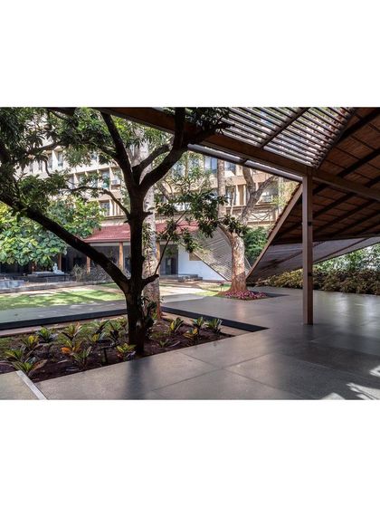 The new event pavilion is designed to be open and flexible, with large openings that connect it to the surrounding gardens and the existing mature trees on the site.