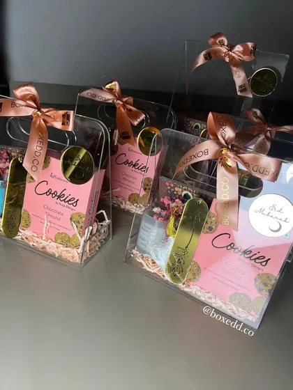 These clear acrylic gift bags are a modern and chic way to present Eid gifts. They are filled with cookies and other treats, perfect for friends and relatives.
