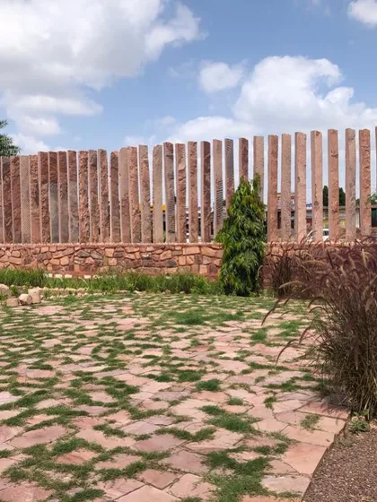 A glimpse of our project in Jodhpur, where we embraced the local landscape. This boundary wall is crafted from vertical slabs of Jodhpur stone, and the ground features a mix of stone paving and native grasses, creating a design that feels born from the earth.