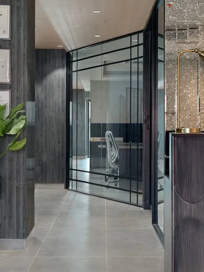 Step into the future of work with this electrifying office design. The dark wood paneling, glass partitions, and modern furniture create a space that is both professional and stylish.