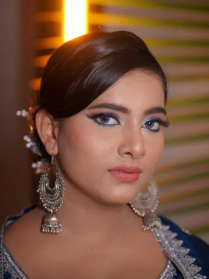 A close-up portrait showcasing the sharp, blue winged eyeliner. This is a great way to add a touch of color to a classic look.