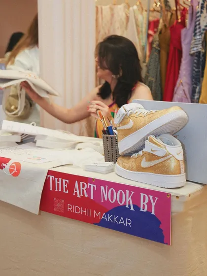 My pop-up stall, "The Art Nook," at a festive edit event. On display are a pair of my custom gold glitter Nike Air Force 1s, showing the kind of detailed work I can do.
