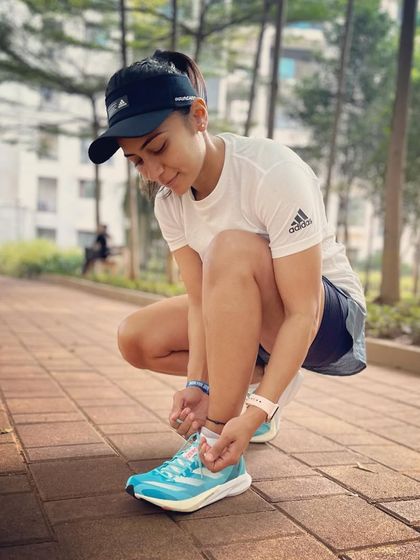 Tying my laces, a simple but crucial pre-run ritual. The right shoes and a secure fit are the first step to a great run. Getting ready to head out for a training session in Delhi.
