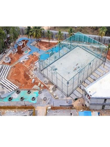 An aerial shot of the Vaishnavi Tech Square recreation zone during construction, showing the layout of the sports court, play areas, and amphitheater.