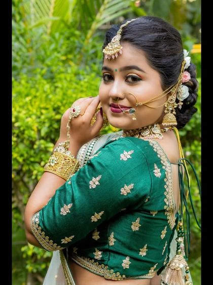 A beautiful bridal portrait focusing on the traditional jewellery, including a nath (nose ring) and hath phool (hand harness), which pair perfectly with the green lehenga.