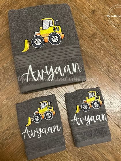 Bring a smile to their bath time routine with this personalized towel set. Featuring an embroidered construction vehicle, this soft cotton towel and napkin set can be customized with any character.