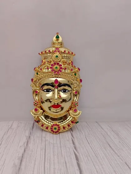 Yeh hamara full gold-plated Lakshmi Mukhavada hai, jispar laal aur hare rang ke stone ka kaam kiya gaya hai. Yeh aapke festival ki सजावट mein ek shahi look dega.