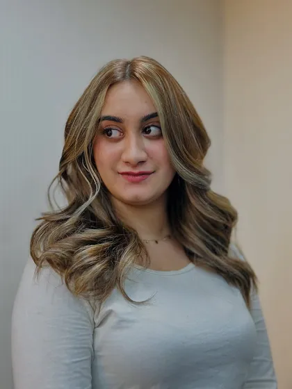A playful glance over the shoulder, showing off the new ash blonde color. It's a versatile look that's full of personality.