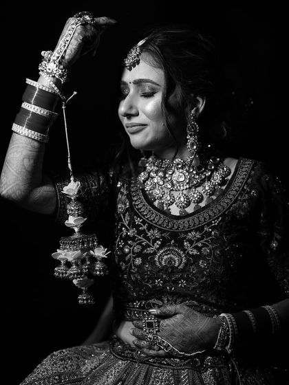 A timeless black and white portrait. This image captures the bride's serene expression and the intricate details of her jewelry and makeup.