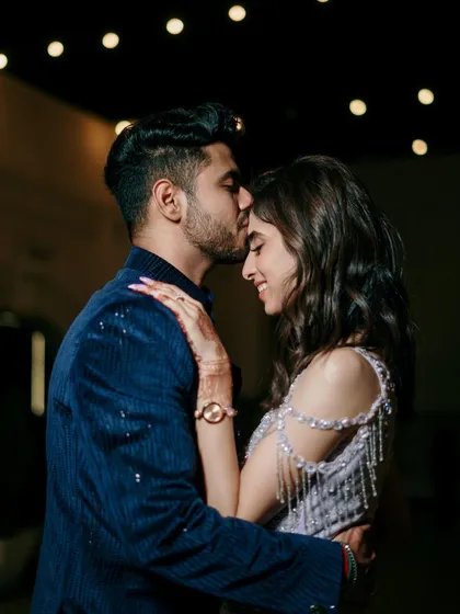A tender forehead kiss, a classic and timeless expression of love, captured beautifully during their outdoor evening photoshoot.