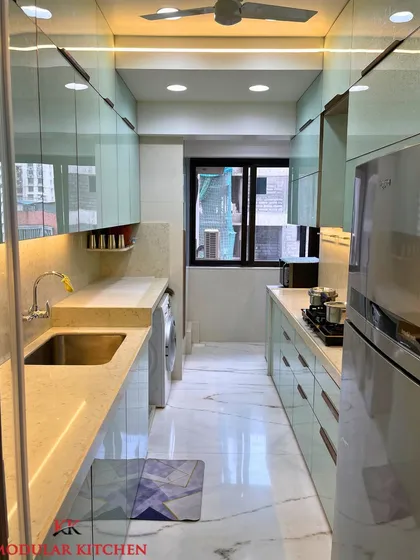 A full view of the parallel kitchen at Garodia Palace, Ghatkopar. The design incorporates a washing machine seamlessly, showcasing how we optimize space without compromising on style.