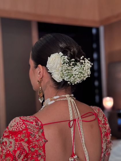 A beautiful bridal updo combining white roses and baby's breath for a classic look.