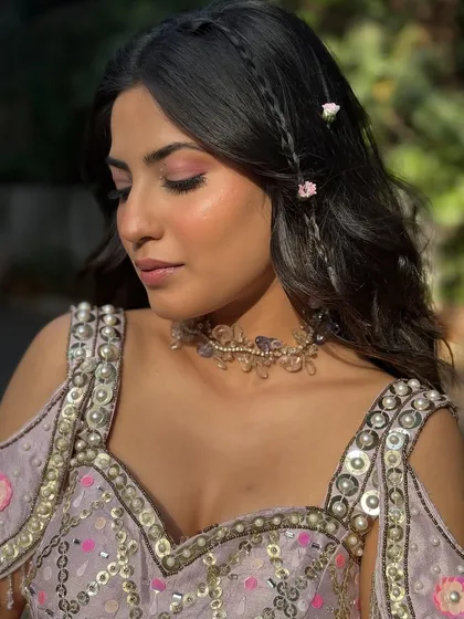 A detailed shot of the rose-toned eyeshadow and the delicate braids woven into her hair. It's these little details that make a look special.