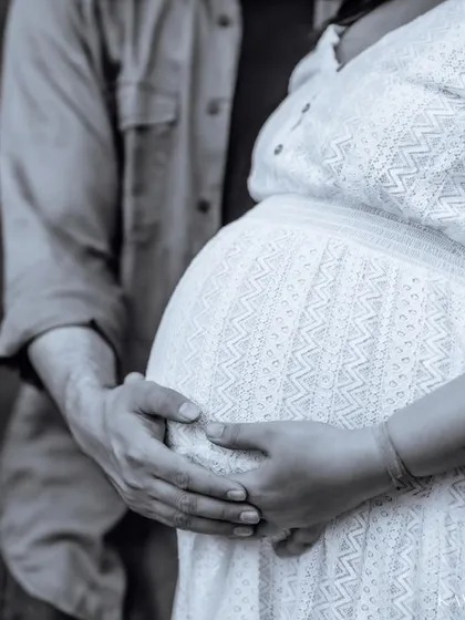 A timeless black and white close-up of a couple's hands on the baby bump. This artistic shot emphasizes the shape and the connection without any distractions.